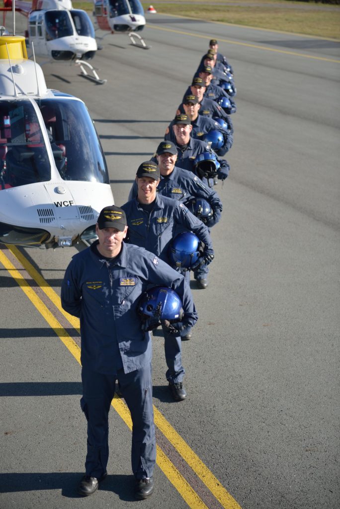 Becker Helicopters Flight Instructors lined up in front of the helicopter fleet