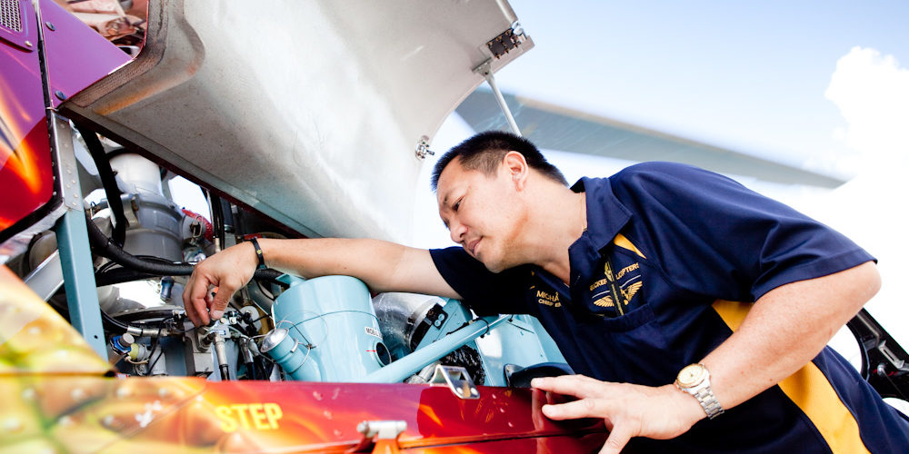 Director of Maintenance, Michael Yip, inspecting the engine bay of AS350D Squirrel Helicopter