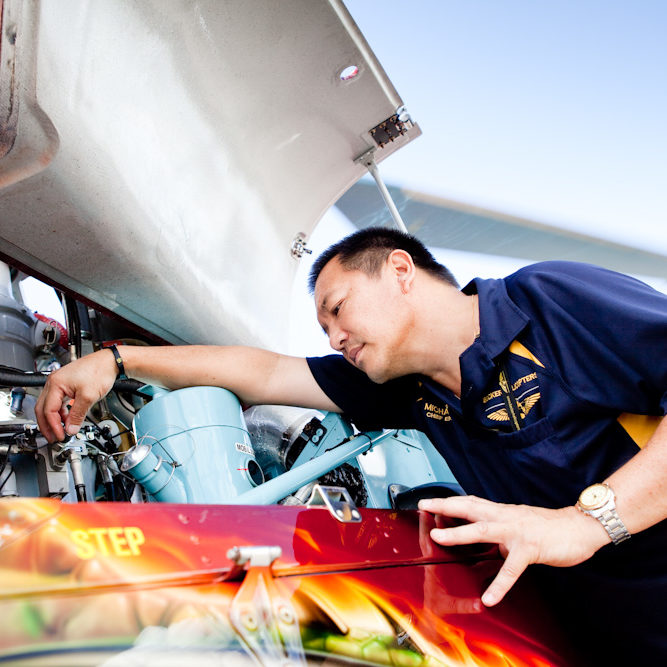 Director of Maintenance, Michael Yip, inspecting the engine bay of AS350D Squirrel Helicopter